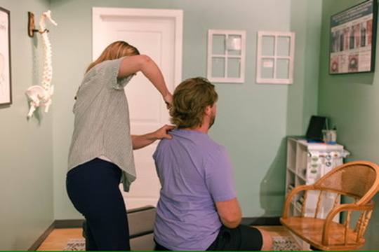 Patient receiving chiropractic neck adjustment at Calmbody Chiropractic Club